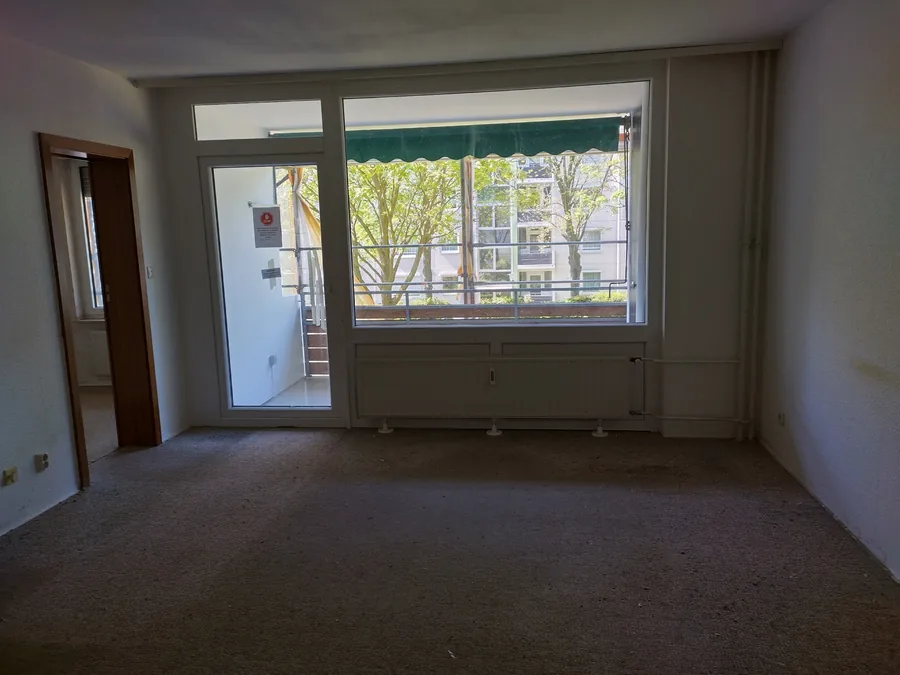 Leere Mietwohnung in Hannover nach der Wohnungsauflösung, Wände frei, Boden gefegt, Fenster ohne Gardinen